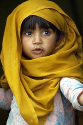 A Pakistani girls looks out from a tent at a camp set up by the government for displaced people.