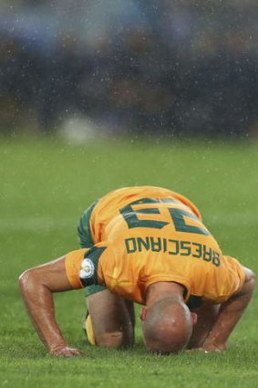On his knees: Mark Bresciano of the Socceroos.