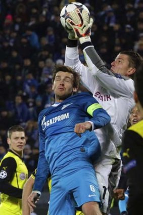 Zenit St Petersburg's Nicolas Lombaerts (L) fights for the ball with Borussia Dortmund's goalkeeper Roman Weidenfeller.