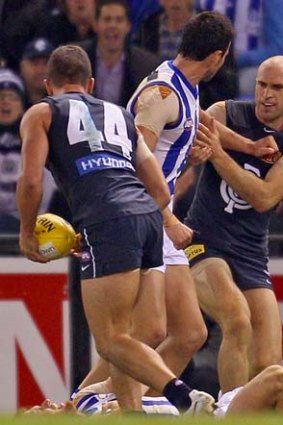 Chris Judd tussles with North Melbourne players after pulling Leigh Adams' arm.