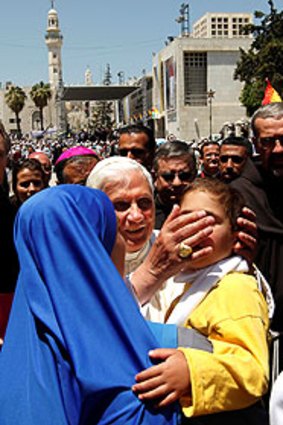 Holy touch: Pope Benedict blesses a child following a mass in Bethlehem.