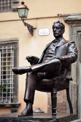 Giacomo Puccini is depicted in his birthplace, Lucca, holding his omnipresent cigar.
