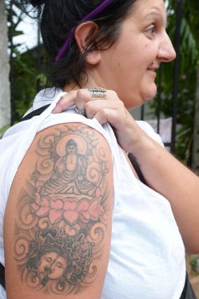 A British tourist displays a tattoo of the Buddha on her upper arm, after she was arrested at Sri Lanka's main international airport.