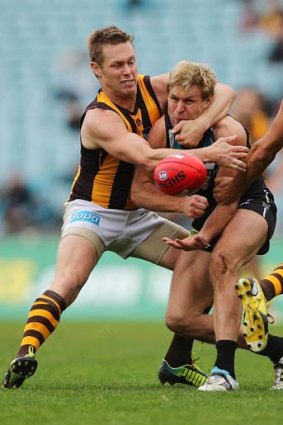 Sam Mitchell of the Hawks tackles Kane Cornes of the Power during the round 16 match between the two teams.