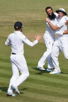 Moeen Ali is congratulated by Joe Root after taking the wicket of Cheteshwar Pujara.
