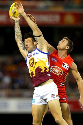 Hands up: Brisbane’s Mitch Clark  and Nathan Bock of Gold Coast were at full stretch last night.