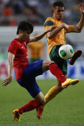 Air shot: South Korea's Kim Chang-Soo challenges Socceroo Dario Vidosic.