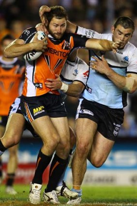 Mitch Brown is crunched by the Sharks defenders.