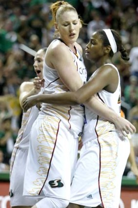 Lauren Jackson of the Seattle Storm  is hugged by Camille Little, right with a pat on the back from Sue Bird, left, after she was fouled on a shot against the Atlanta Dream.