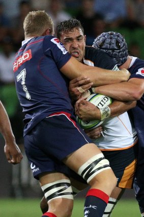Rory Arnold of the Brumbies (centre) is tackled by Angus Cottrell (left) and Ross Haylett-Petty of the Rebels.