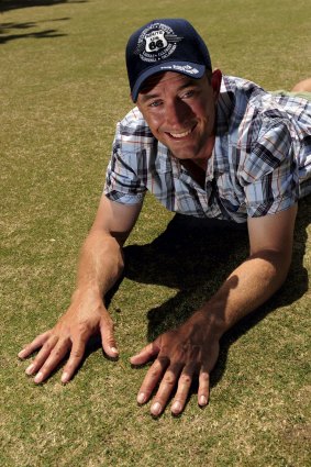 Tennis Australia turf consultant Shayne Ried  checks out some grass. 
