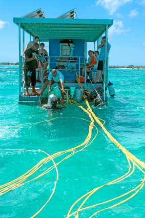 Underwater walkers prepare to descend from a platform anchored over the reef close to Grand Bay, Mauritius.