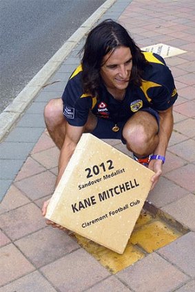 Kane Mitchell installs his 'paver' on the Sandover walk-of-fame in Subiaco. <b>Photo:</b> wafl.com.au