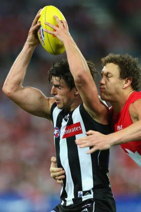 Wrapped up: Scott Pendlebury is tackled by Swan Shane Mumford in Friday night's match.