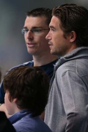 Harry Kewell (right) watches the Australian swimmers train in Manchester.