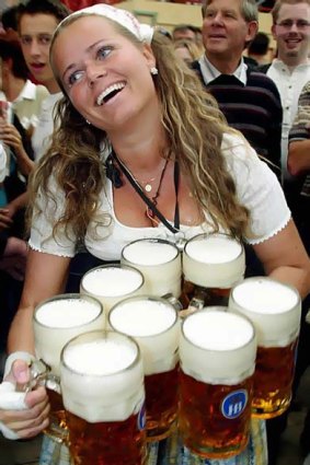 A waitress carries one-litre beer mugs during the opening day of Oktoberfest in Munich. <i>Photo: Reuters/Alexandra Winkler</i>