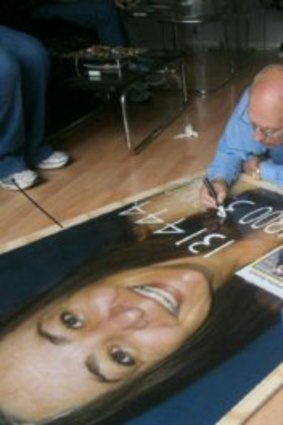 Darrell Baldock preparing a poster of his missing daughter, Samantha.