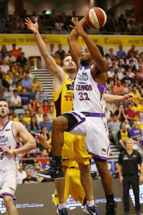 Man of action: Sydney Kings import Sam Young slam dunks over Mark Worthington of the Melbourne Tigers on Sunday.