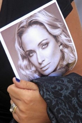 A mourner holds a photo of Reeva Steenkamp at her funeral in February 2013.