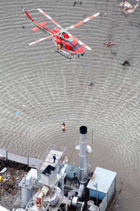 A helicopter hovers to conduct a rescue operation in Sendai, northern Japan.