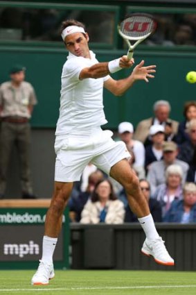 Roger Federer plays a forehand during his first-round match against Victor Hanescu of Romania.