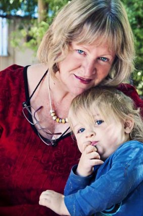 Two-year search ... childcare centre owner Cathy Carroll, holding Harvey Willoughby, is unable to find university qualified staff.