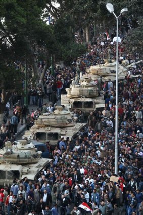 Demonstrators demanding the end of the Mubarak regime gather around army tanks in Cairo.