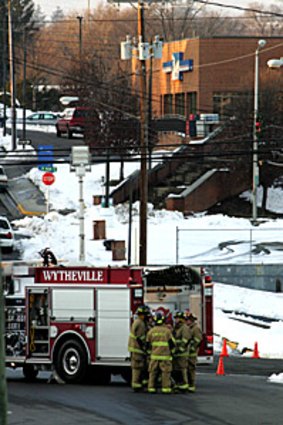 Volunteer firefighters stand near the Wytheville Post Office, where a man allegedly held hostages.