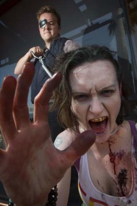 Role players husband and wife duo, John Randolph (L) and Vylet Randolph, pose dressed as the Governor and a zombie respectively from <i>The Walking Dead</i> television and comic series.