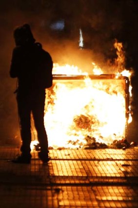 A protester walks by a burning barricade in Athens.