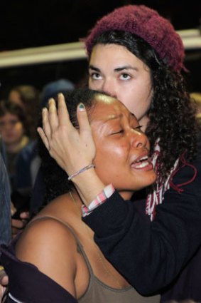 Tears ... a woman comforts another during the raid.