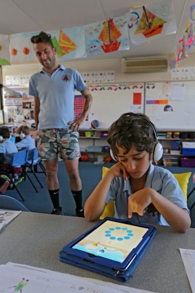 Teacher Matt Serres watches on as grade 1 student Niv Braverman uses the maths  app at Tucker Road Primary.  It works on improving memory. 