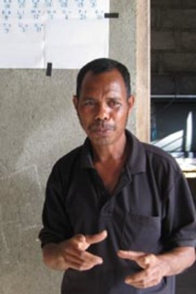 By the book...Cuban literacy instructor Gregorio de Costa in Motakilk, East Timor.