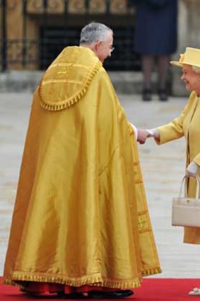 Mellow in yellow... a relaxed Queen Elizabeth is greeted by the Right Reverend Dr John Hall, Dean of Westminster.