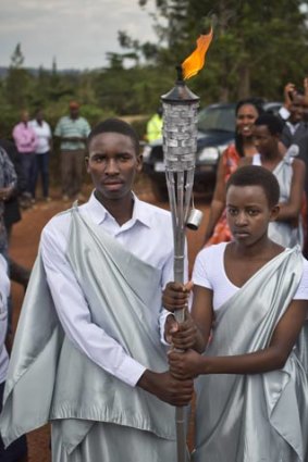 Youths carry a flame of remembrance to a ceremony last week where villagers from surrounding areas gathered to hear genocide memories, in the town of Kirehe, eastern Rwanda.
