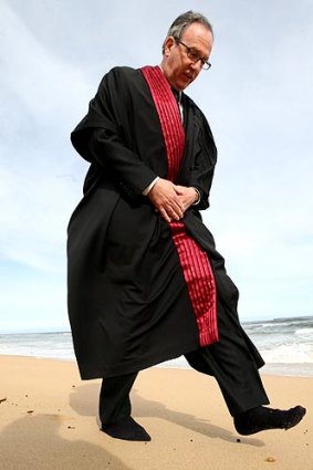 Federal Court judge Tony North, with shoes off to feel the land, on Victoria's south-west coast yesterday.