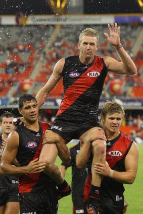 Dustin Fletcher of the Bombers is carried from the field after his 350th game.