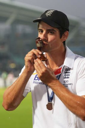 Alastair Cook kisses the urn.