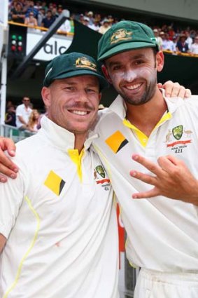 I got three: Nathan Lyon indicates how many wickets he took in England's second innings as he poses with David Warner.