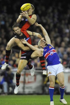 Bulldog Jason Akermanis is besieged by Bombers Michael Hurley and Mark McVeigh on Friday night.