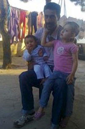 Broken Man: Hussein Khodor, with two of his eight children, all of whom died.