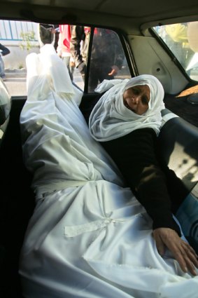 The mother of a Palestinian victim cries as she leaves Al-Shifa hospital with his body.