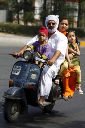 A family pack onto a scooter and brave the traffic in  New Delhi.