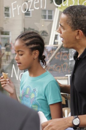 President Barack Obama shares a dessert with daughter Malia.