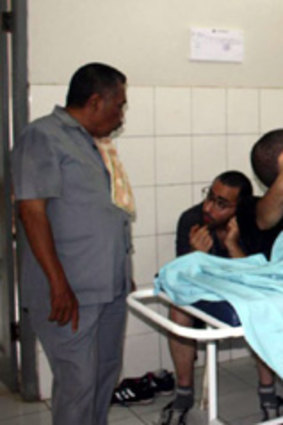 Two asylum seekers take a rest as local officers provide medical treatment in Ciamis, West Java.