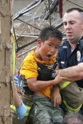 Rescued: A boy is pulled from beneath a collapsed wall at the Plaza Towers Elementary School.
