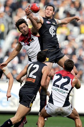 First hands: Blue Robbie Warnock outpoints Demon Stefan Martin in a ruck contest yesterday.