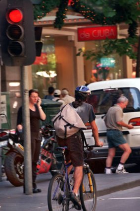 A cyclist appears to ignore a red light on Collins Street, Melbourne.