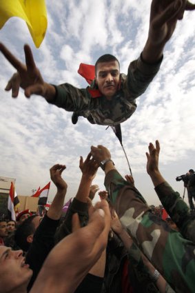 A Syrian soldier flashes the victory sign as he is thrown in the air during a pro-regime rally in Damascus.