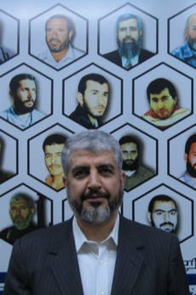 Mishal flanked by a mural of 20 Hamas leaders, fighters and bomb-makers who were killed in Israeli assassinations.